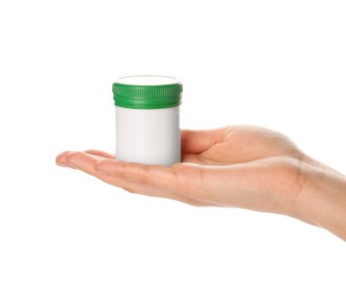 Beyaz arka planda ilaç şişesi tutan kadın.