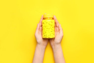 Arka planda ilaç şişesi olan kadın elleri.