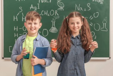 Sınıftaki kimya dersinde tahtaya yakın şirin çocuklar.