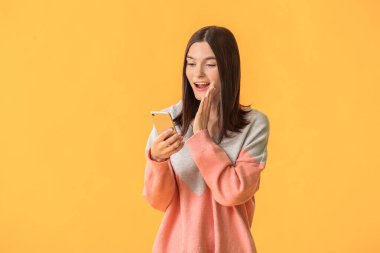 Renkli arka planda cep telefonu olan güzel bir kadın.