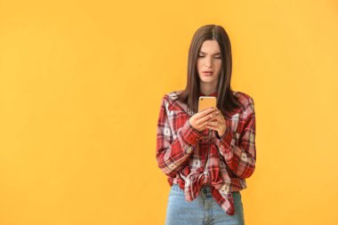 Arka planda cep telefonu olan sorunlu genç bir kadın.