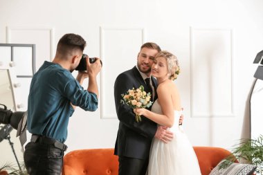 Photographer working with young wedding couple in studio