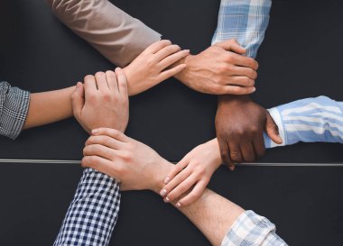 İçeride el ele tutuşan bir grup insan. Birlik kavramı