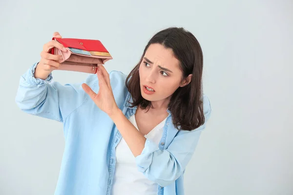 Besorgte Junge Frau Mit Leerem Portemonnaie Auf Hellem Hintergrund — Stockfoto