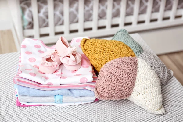 Babykleidung Mit Stiefeln Und Kopfkissen Auf Dem Tisch Zimmer — Stockfoto