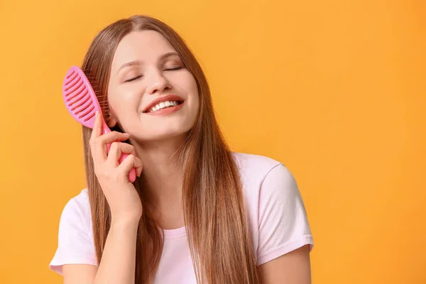 Красивая Молодая Женщина Расчесывает Волосы Цветном Фоне — стоковое фото