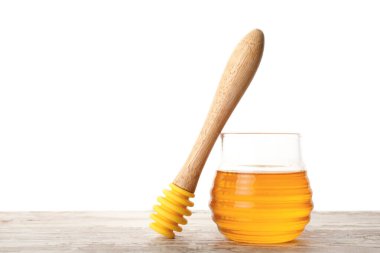 Masada beyaz arka planda duran tatlı bal kavanozu