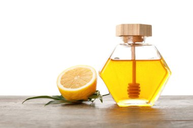 Beyaz arka planda tatlı bal ve limon kavanozu