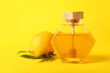 Renkli arkaplanda tatlı bal ve limon kavanozu