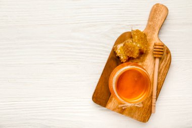 Tatlı bal kavanozu, dipper ve ahşap arka planda taraklar