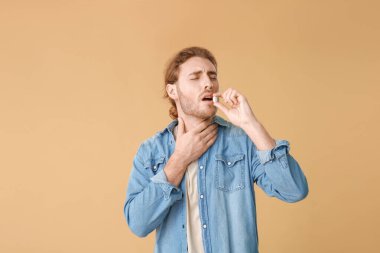 Renkli arka planı olan hasta bir genç.