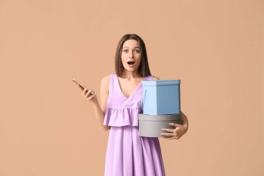 Cep telefonu ve renkli kutuları olan genç bir kadın. Çevrimiçi alışveriş kavramı