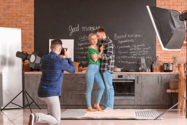 Photographer working with young couple in studio