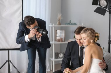 Photographer working with young wedding couple in studio