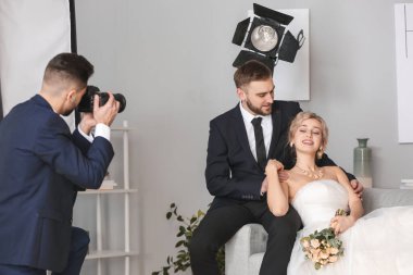 Photographer working with young wedding couple in studio