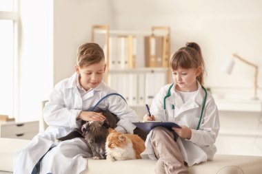 Klinikte hayvanları inceleyen küçük veterinerler.