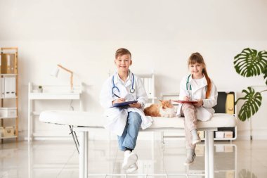 Klinikte şirin kedileri muayene eden küçük veterinerler.