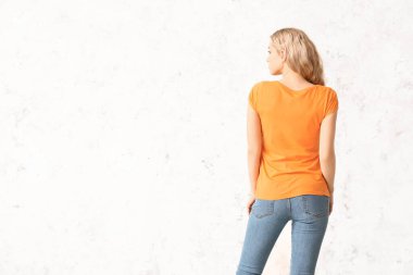 Hafif arka planda şık tişörtlü kadın.