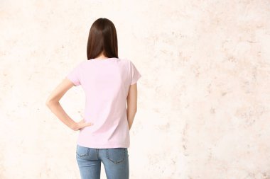 Hafif arka planda şık tişörtlü kadın.