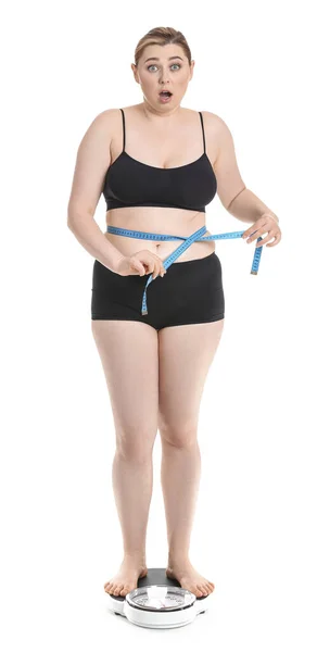 白い背景を背景に体重計に立って太りすぎの女性ショックを受けた 減量の概念 — ストック写真