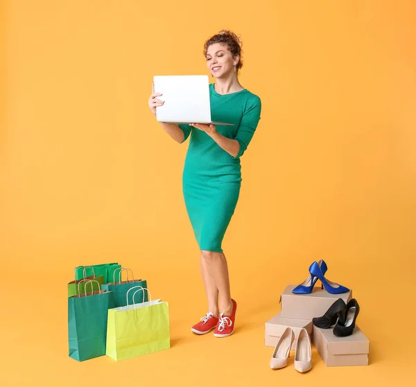 Jonge Vrouw Met Laptop Boodschappentassen Kleur Achtergrond — Stockfoto