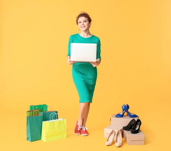 Jonge Vrouw Met Laptop Boodschappentassen Kleur Achtergrond — Stockfoto