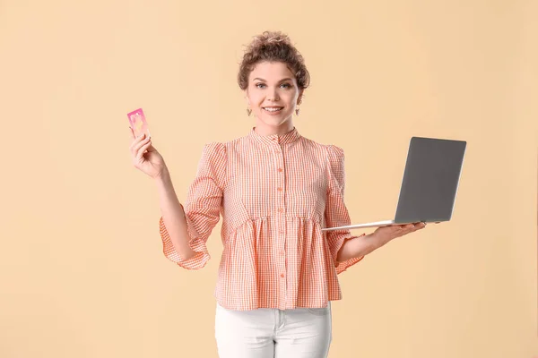 Schöne Junge Frau Mit Laptop Und Kreditkarte Auf Farbigem Hintergrund — Stockfoto