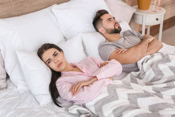 Sad couple after quarrel in bedroom