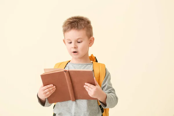 Overrasket Liten Gutt Leser Bok Fargebakgrunn – stockfoto