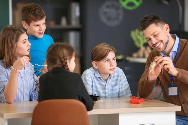 Teacher conducting physics lesson in classroom