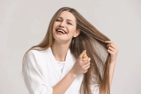 Hermosa Mujer Joven Con Spray Para Cabello Sobre Fondo Claro —  Fotos de Stock