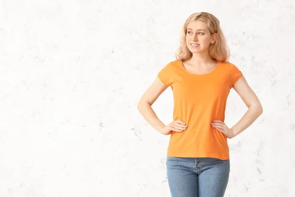 ライトバックにスタイリッシュなTシャツの女性 — ストック写真