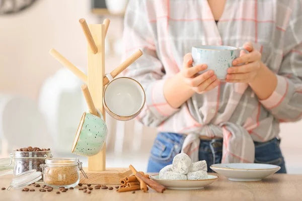 Woman drinking hot coffee in kitchen