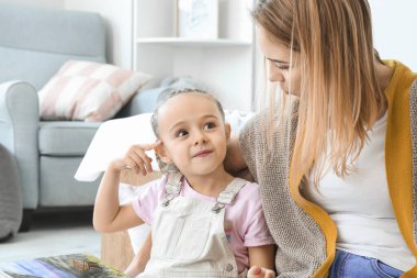 Dadı ve evde kitap okuyan tatlı küçük kız.