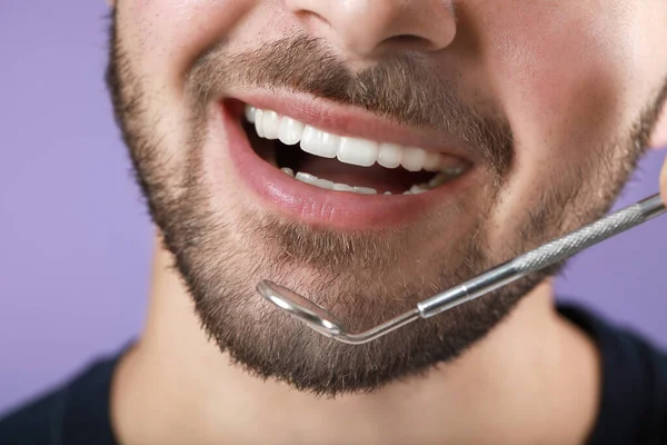 Glad Leende Ung Man Med Dentalspegel Färg Bakgrund Närbild — Stockfoto
