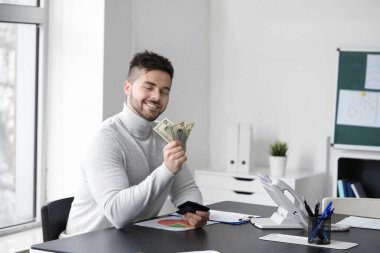 Man counting money in office