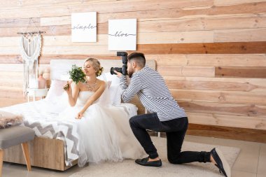 Stüdyoda genç gelinle çalışan bir fotoğrafçı.