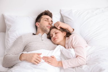 Genç çift yatakta uyuyor.