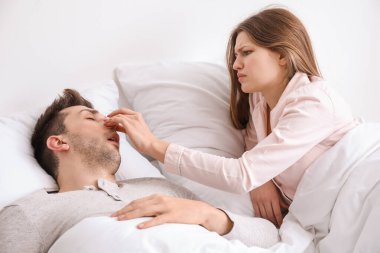 Yatakta sinirli bir kadın ve evde horlayan bir koca.