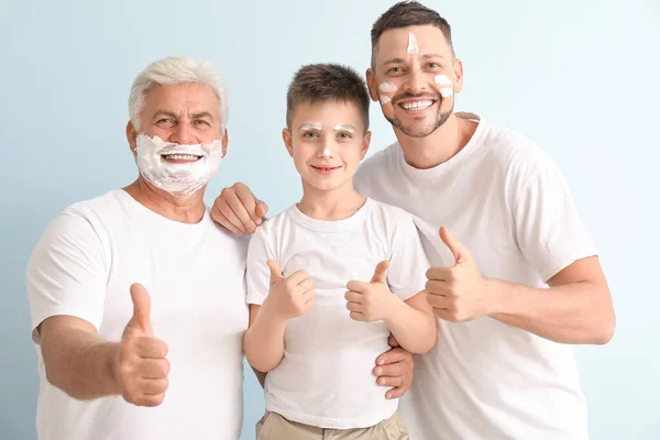 彼らの顔にシェービングフォームを持つ男 彼の父と息子は 色の背景に親指アップジェスチャーを示しています — ストック写真
