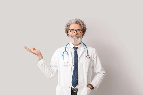 Portrait Senior Male Doctor Showing Something Grey Background — Stock Photo, Image