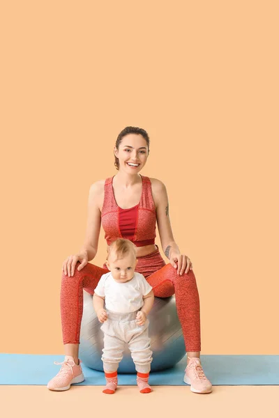 Young Sporty Mother Her Baby Doing Exercises Fitball Color Background — Stock Photo, Image