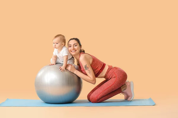 Young Sporty Mother Her Baby Doing Exercises Fitball Color Background — Stock Photo, Image