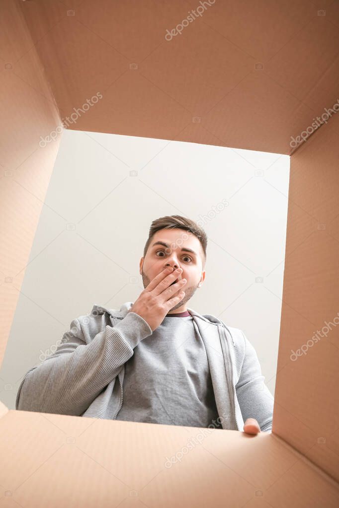 Shocked man with open box, view from inside