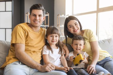 Mutlu bir aile evdeki kanepede oturuyor.
