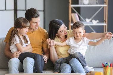 Mutlu bir aile evdeki kanepede oturuyor.