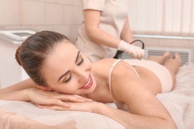 Güzeller güzeli kadın güzellik salonunda anti-selülit masajı yaptırıyor.