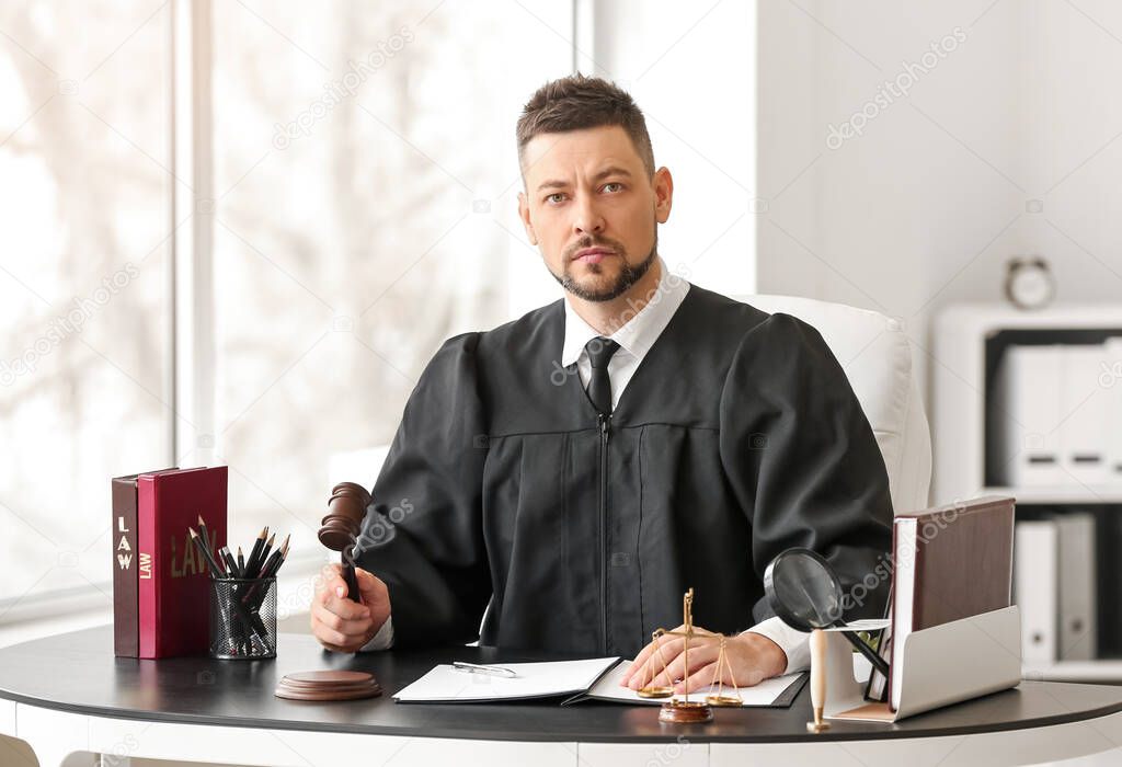 Male judge working at table in office