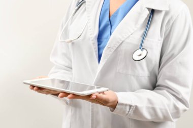 Açık arkaplanda tablet bilgisayarı olan kadın doktor