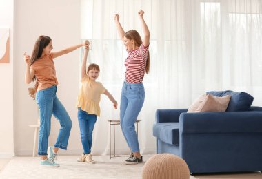 Evlatlık kızıyla evde dans eden mutlu lezbiyen çift.